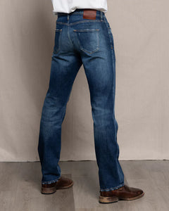 Back view of men’s Harlan Straight Easy Rider jeans in medium-dark Candiani denim, shown with boots.