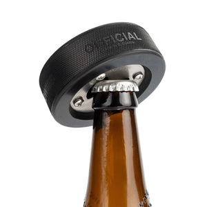 Hockey puck bottle opener, showing use with a beer bottle