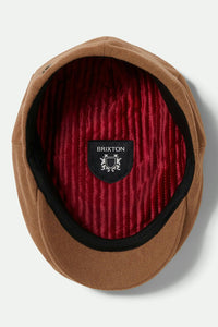Inside view of the Brixton Hooligan Flat Cap in camel showing the quilted red liner and Brixton crest label.