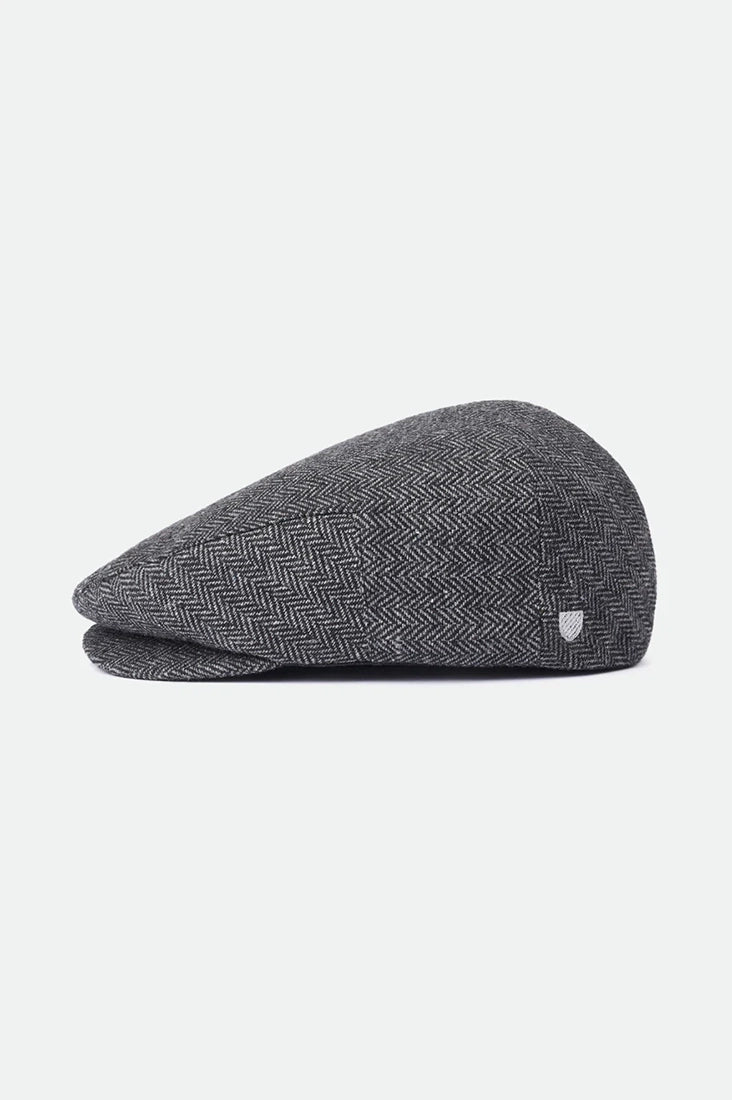 rixton Hooligan Snap Cap side profile on white background – grey black herringbone structured flat cap short brim elevated crown men's accessory