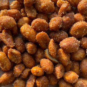 Honey roasted peanuts with a reddish hot BBQ seasoning coat, close detail view