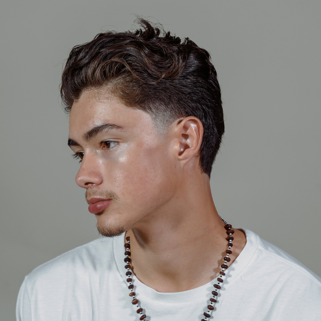 Young man with tousled, textured dark hair, styled with Hybridized Wax