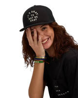 We Are Enough It's Okay Trucker Hat in Real Black front view showing embroidered It's Okay text