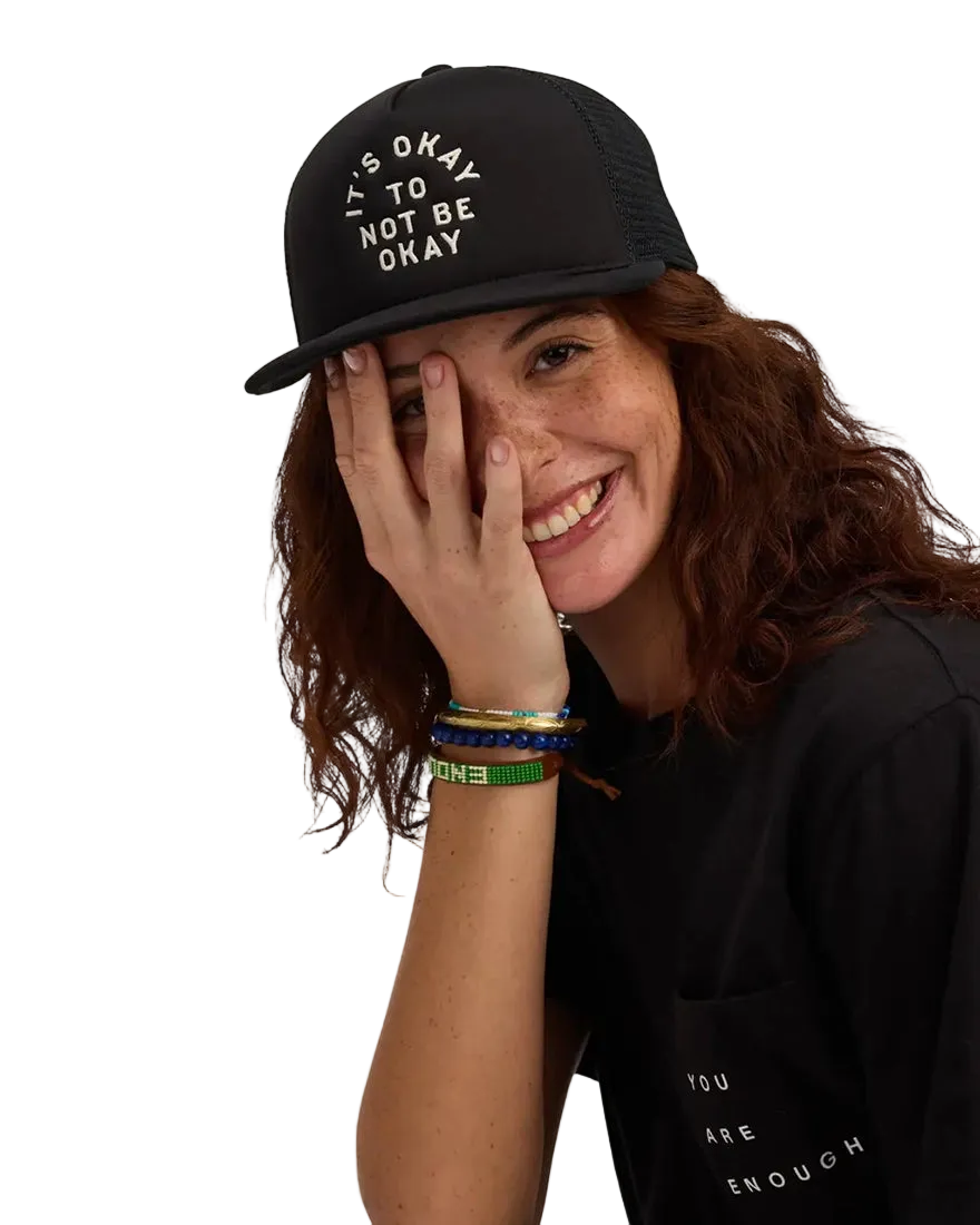 We Are Enough It's Okay Trucker Hat in Real Black front view showing embroidered It's Okay text