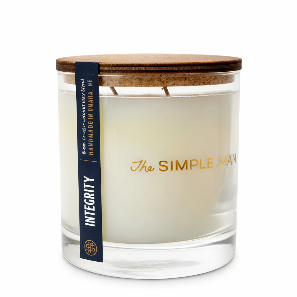 Candle with a wooden lid and 'The Simple Man' branding on a white background