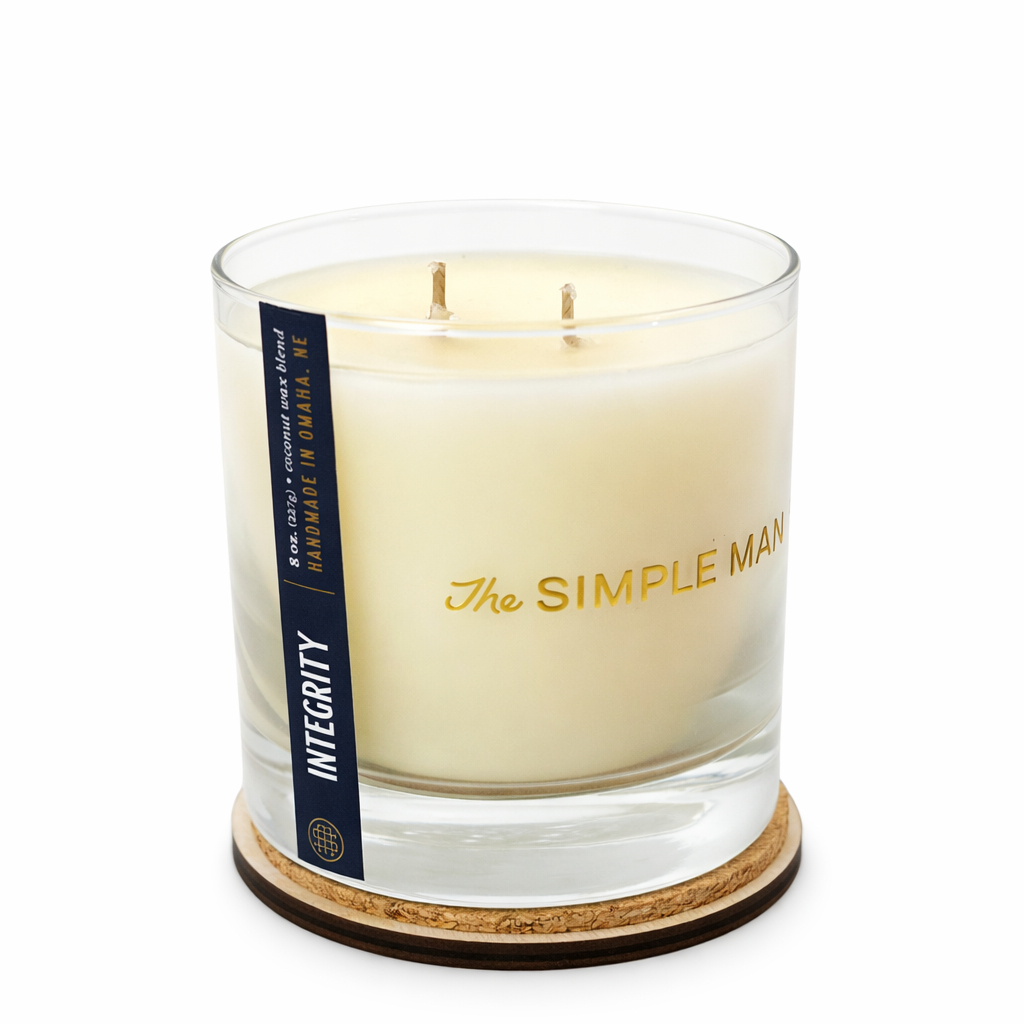 Candle with 'The Simple Man' branding on a white background, lid off