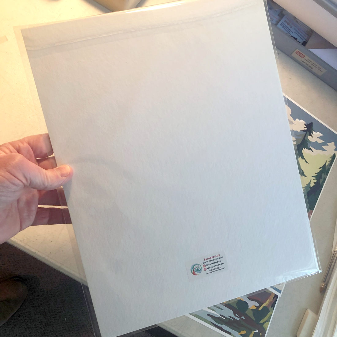 Back of an 11x14 print packed flat in a clear sleeve with a backer board and a small label, The Simple Man
