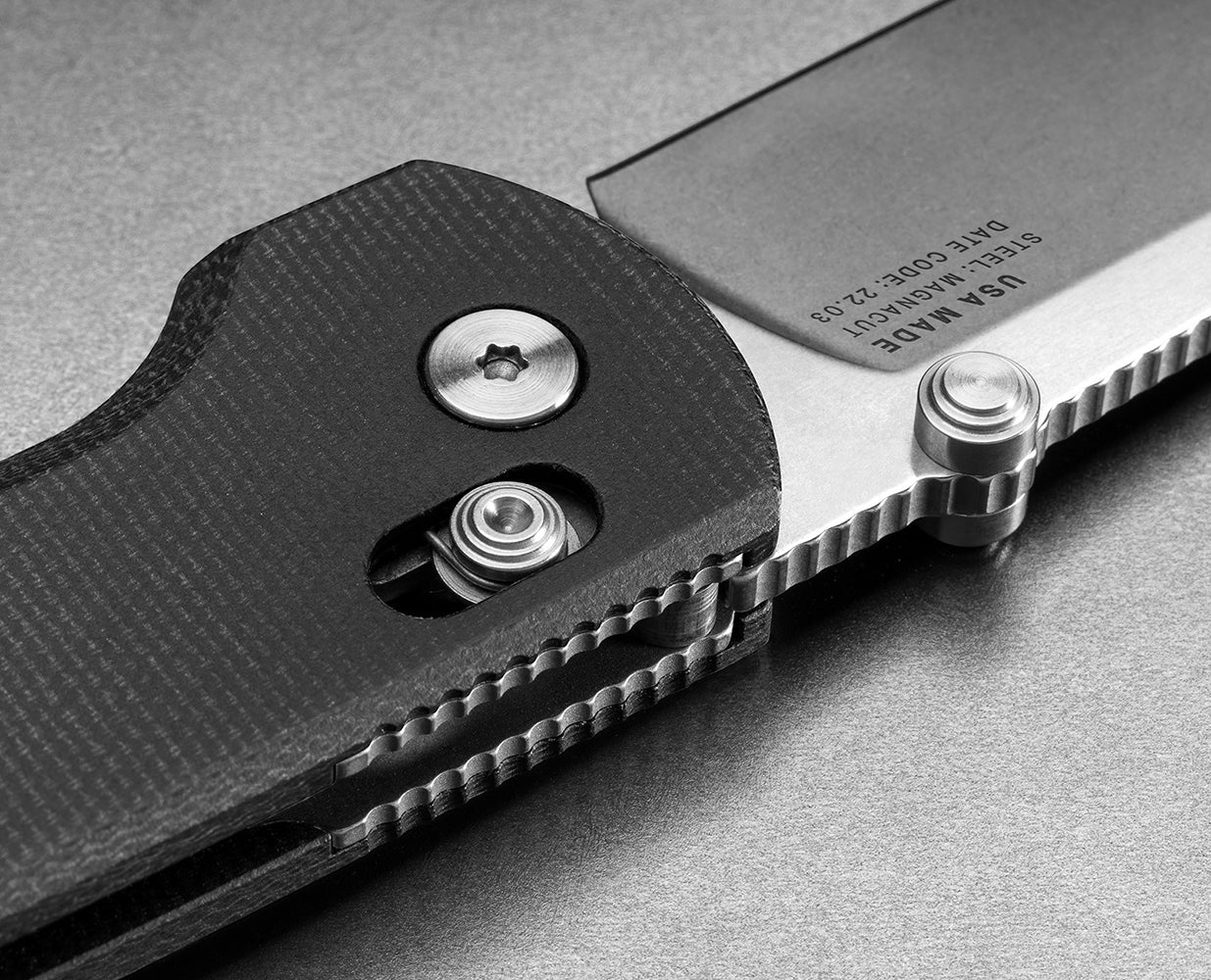 Close-up of American-made pocket knife showing slide-lock mechanism and black Micarta scales