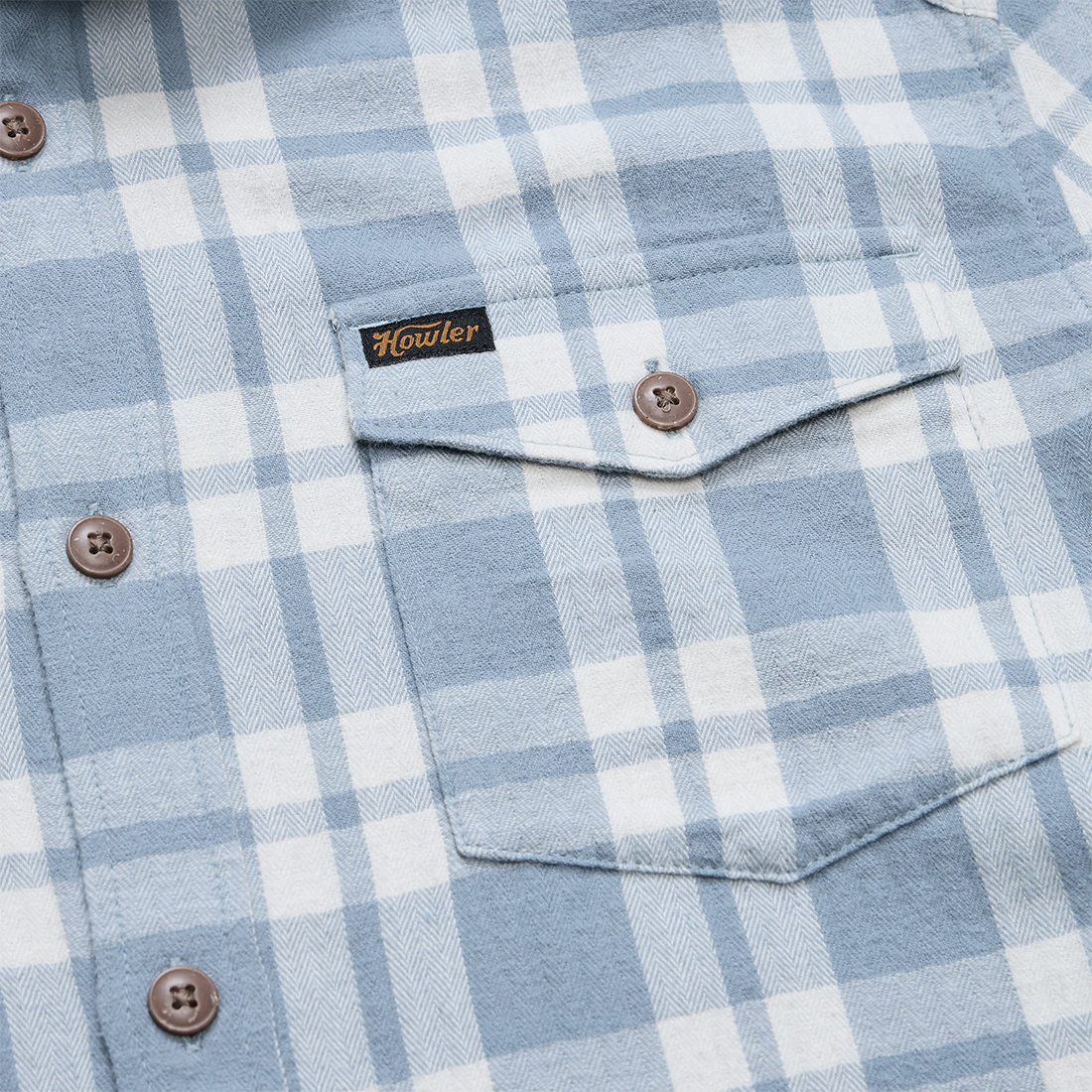 Close-up of the flap chest pocket, Howler woven label and brown coconut buttons on the Iron Blue La Grange Lightweight Flannel, The Simple Man
