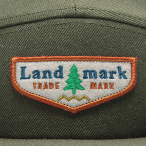 The Landmark Project scout cap in Olive Green up close logo view