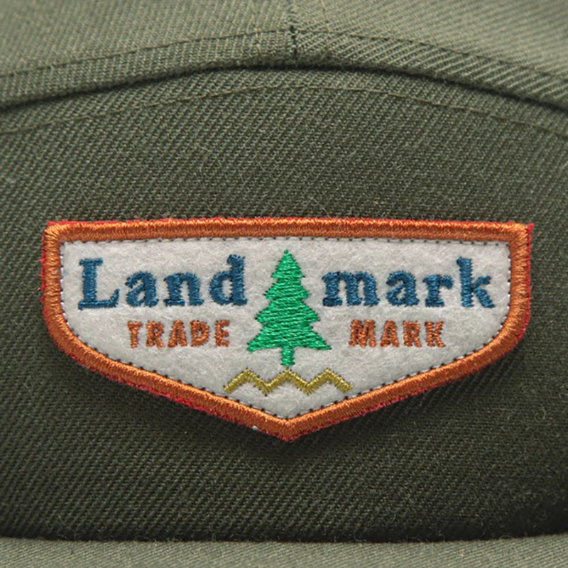 The Landmark Project scout cap in Olive Green up close logo view