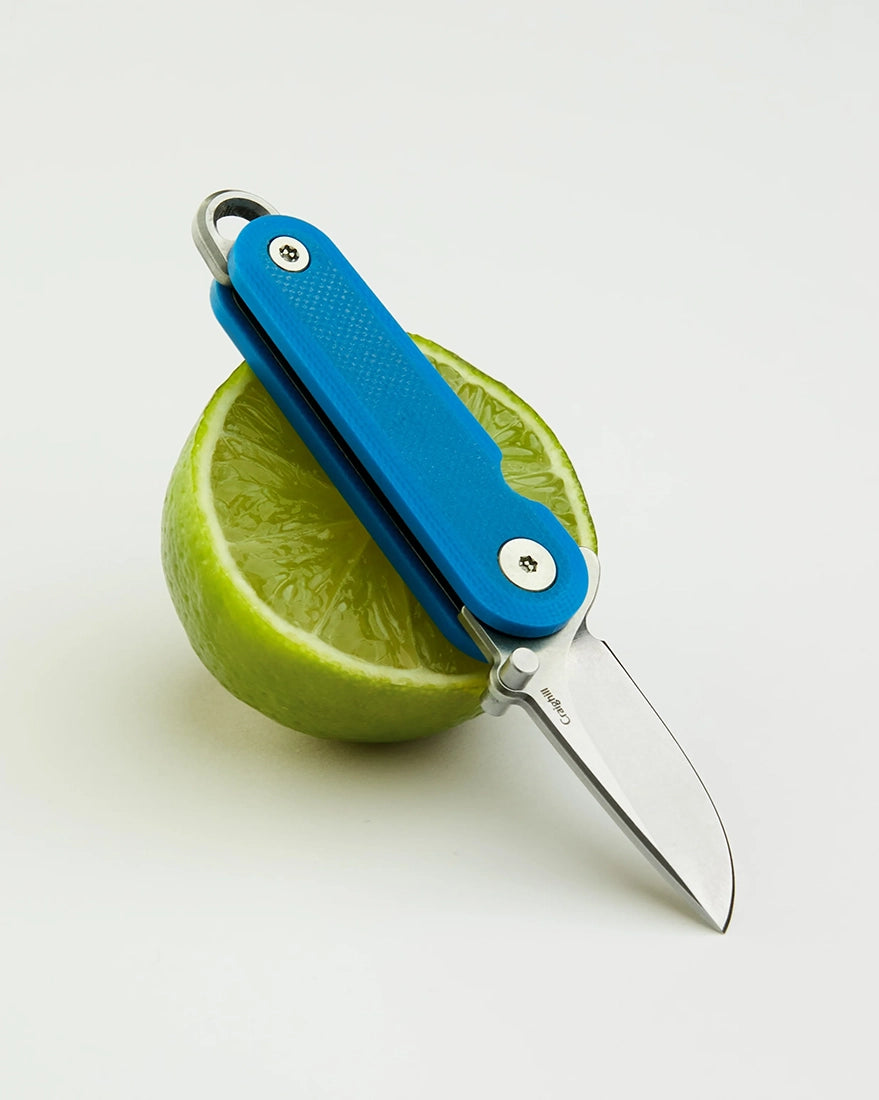 Blue G10 keychain knife cutting citrus fruit for daily utility