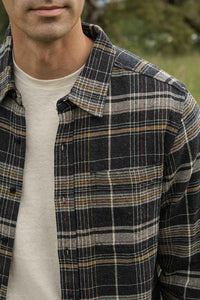 Close-up of The Larson brushed flannel shirt in volcanic plaid showing soft midweight fabric and chest pocket detail.