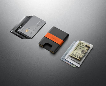 The Lowe minimalist black aluminum wallet shown with cards, cash, and everyday carry items