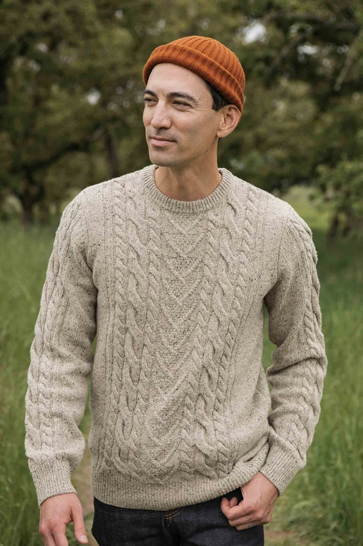 Model outdoors wearing Bridge & Burn’s Ludlow Sweater in oatmeal wool cable knit, available at The Simple Man Omaha