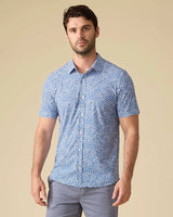 Man wearing Flag and Anthem MadeFlex blue floral stretch shirt with gray chinos – tailored athletic fit men's short sleeve button-down