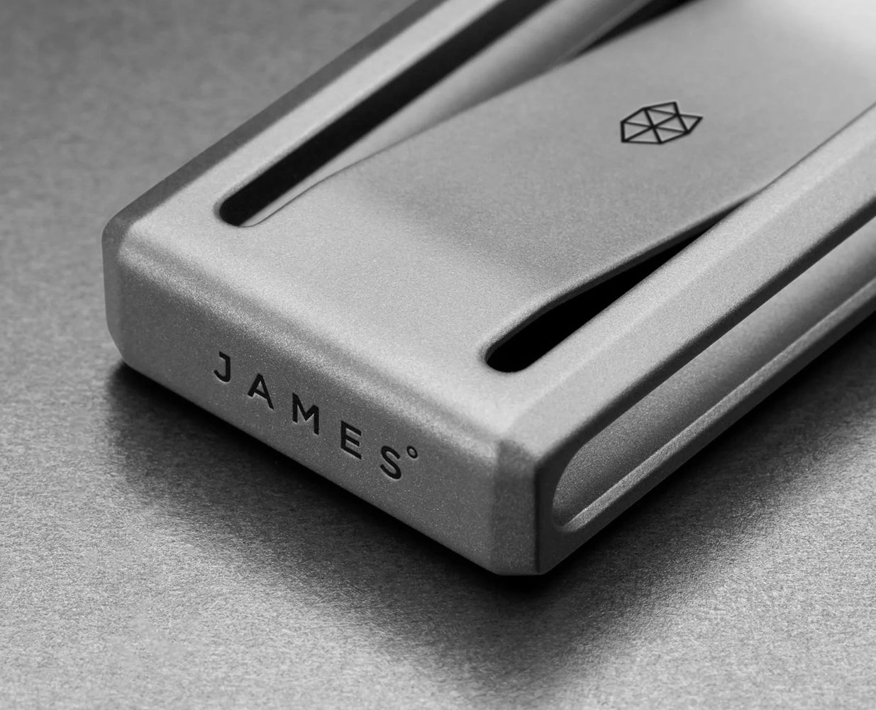 Close-up of The James Brand Martindale titanium money clip with etched logo detail
