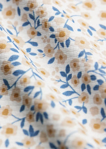 Close-up of Mercer shirt fabric – blue tan and gold micro floral print on white stretch knit men's short sleeve shirt