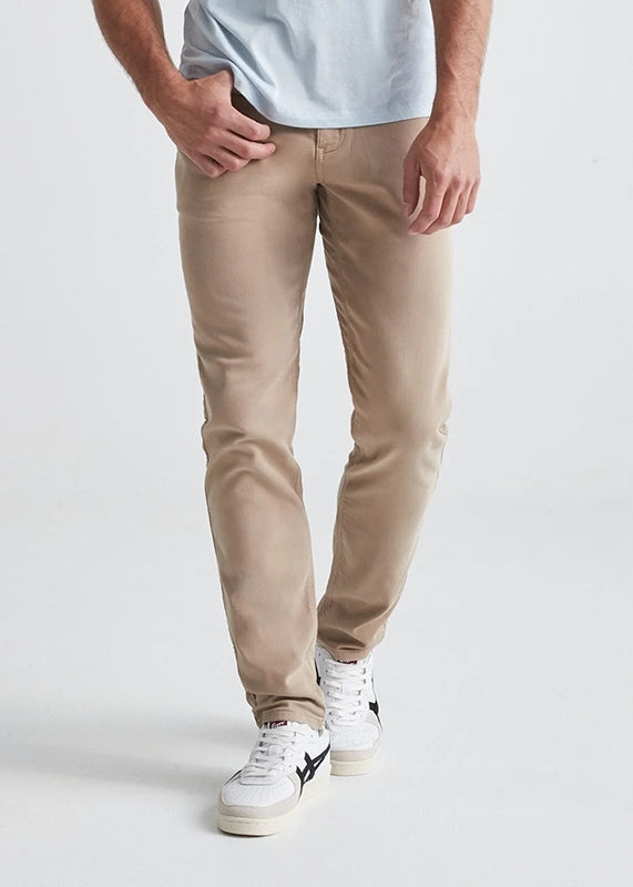 Model wearing Duer No Sweat Slim pants in Desert Khaki color, front view