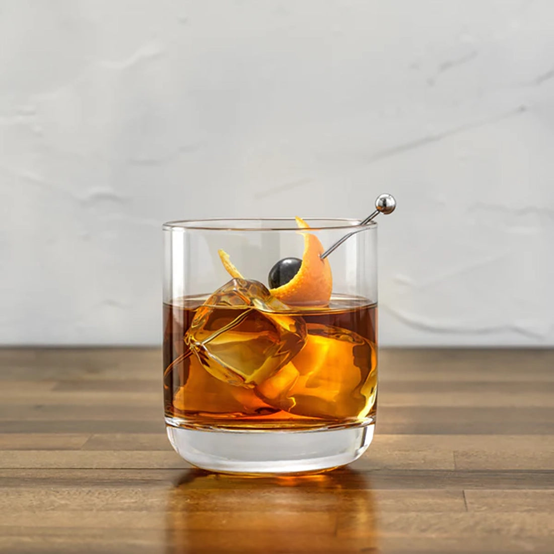 oyJolt Nova whiskey glass close-up with old fashioned cocktail large ice cube and orange peel garnish – lead-free crystal 10oz tumbler