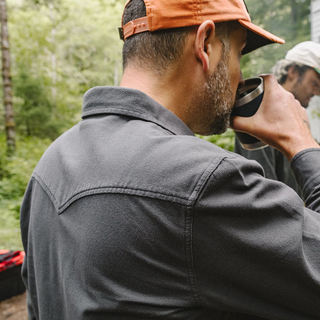Back view of man wearing the Novato Shirt in Antique Black, charcoal grey cotton western snap shirt, outdoor lifestyle shot -- The Simple Man
