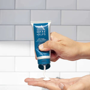 Oars & Alps Dry Hand Repair Cream in Tube package, front view with model hand squeezing tube