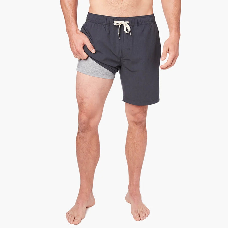 Model Wearing Fair Harbor One Short in Grey, front view with legged pulled up showing the liner