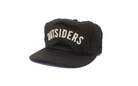 OUTSIDERS Dry Wax Strapback hat in black with felt lettering, shown from a front angle for detail on the unstructured crown