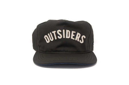 Front view of the OUTSIDERS Dry Wax Strapback with cream felt appliqué lettering on a black dry wax sailcloth cap