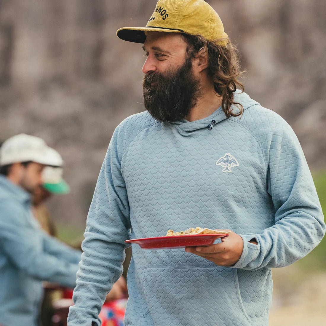 Man wearing light blue fleece hoodie with zig-zag texture at outdoor campsite