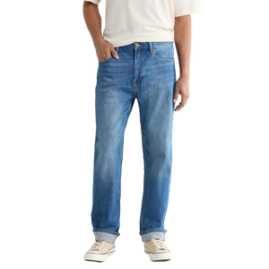 Front view on model of Pembridge wash Preston jeans worn with a cream tee and cuffed hems over sneakers