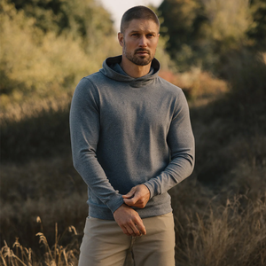 Man wearing Puremeso Essential Hoodie in Bluestone outdoors with hood up
