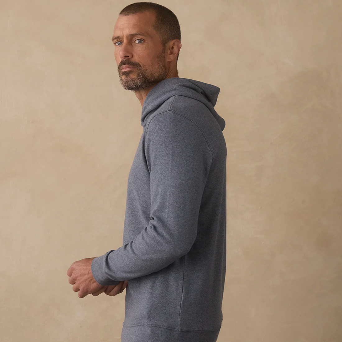 Man wearing Puremeso Essential Hoodie in Bluestone, side profile view