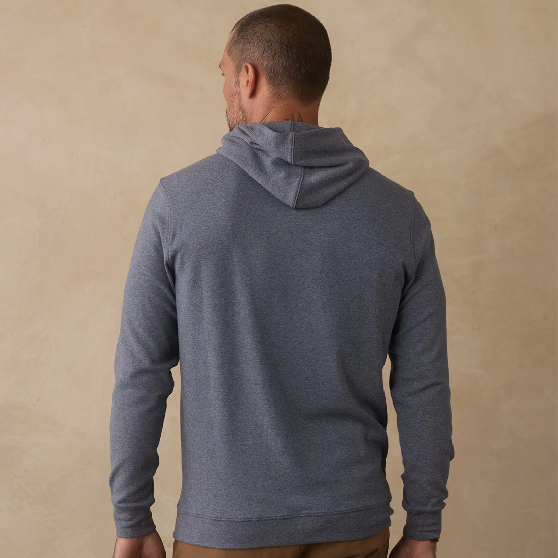 Man wearing Puremeso Essential Hoodie in Bluestone, back view showing hood and fit