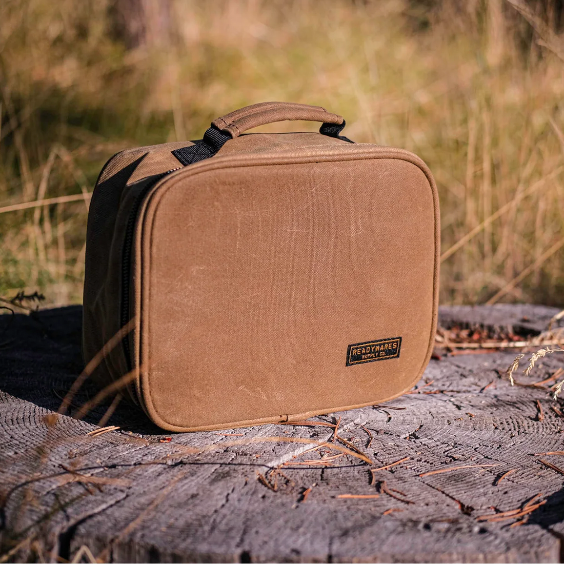 Readywares Waxed Canvas Lunch Box, lifestyle shot outdoors on a tree stump