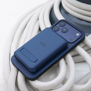 Dark Harbor power bank snapped to the back of a phone, resting on a coil of white rope
