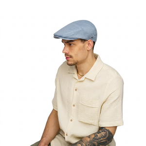 Roan Flat Cap Blue – side view on model showing men's contour 5-panel flat cap profile in textured blue cotton blend