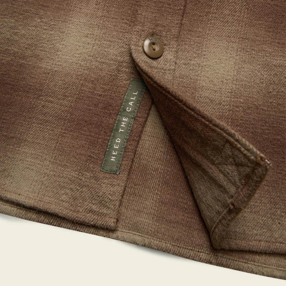 Close-up of Rodanthe Blanket Flannel in Aloe showing interior flap detail and “Heed the Call” tag – heavyweight cotton shirt-jacket