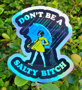 Holographic Don’t Be a Salty Bitch vinyl sticker displayed outdoors – rugged and weatherproof humor sticker for everyday use