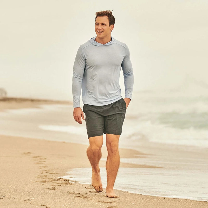 Model wearing Fair Harbor Seabreeze hoodie while walking on the beach
