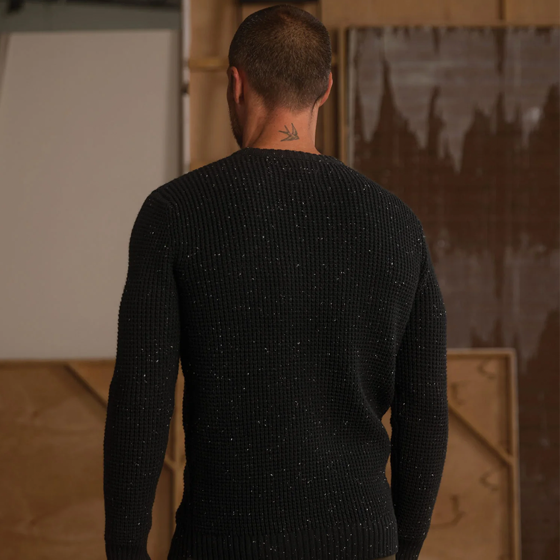 Man wearing Seawool Nep Crew sweater in Charcoal, back view showing waffle knit texture