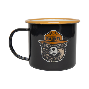 Navy enamel camp mug with gold rim and Smokey Bear's face on the side, front view