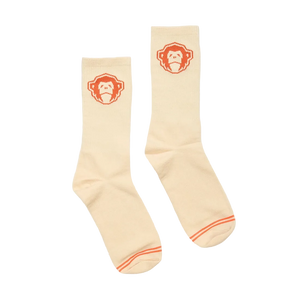 Man wearing El Mono Socks in Sand Orange with suede moc-toe shoes, cream crew socks with orange monkey graphic, lifestyle shot -- The Simple Man