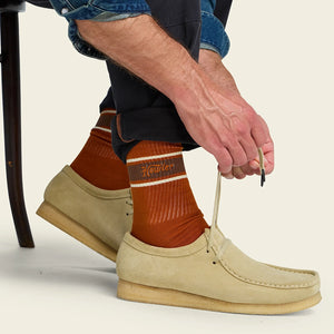 Man wearing Howler Script Socks in Burnt Orange with suede moc-toe shoes, rust orange crew socks with brown stripe, lifestyle shot -- The Simple Man