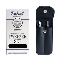 Stainless steel tweezer set in a black vegan leather snap case beside its retail box