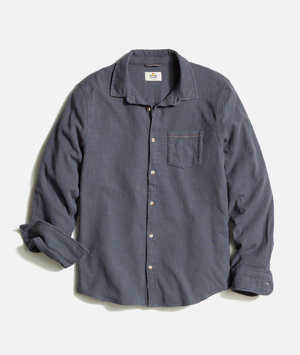 Flat lay of men’s stretch selvage long sleeve shirt in India Ink with pearl buttons