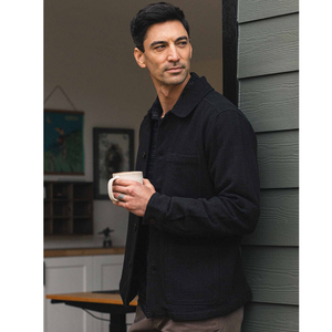 Man wearing Studio Chore Coat in Washed Black buttoned over plaid shirt, close-up on collar and chest pocket - The Simple Man