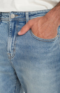 Close-up of light wash stretch denim texture and front pocket detail