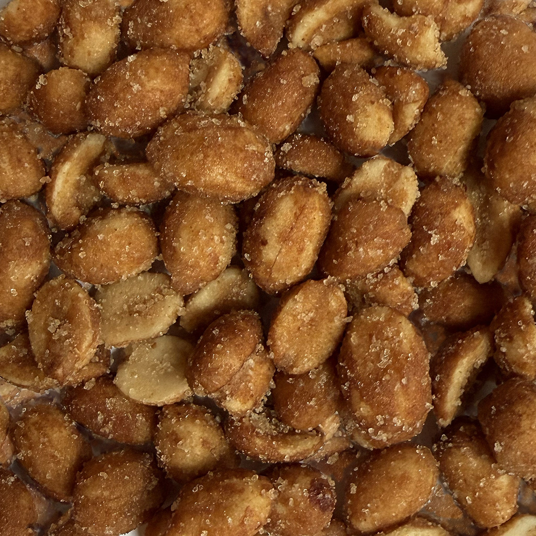 Close-up of roasted peanuts with a sugary, smoky seasoning coating, detail view