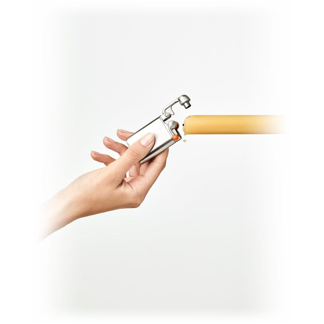Hand lighting a candle with the stainless steel Swingtop Lighter - The Simple Man
